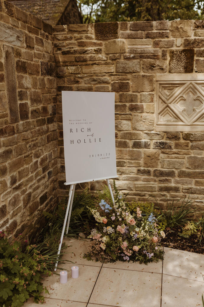Welcome sign on an easel with flowers and candles