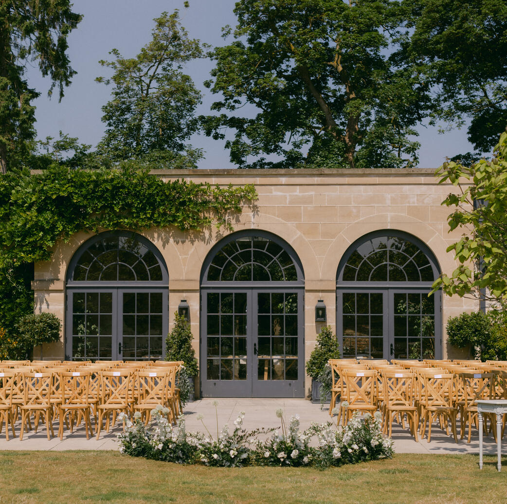 An outdoor wedding ceremony set up at The Fig House dressed with a meadow of flowers