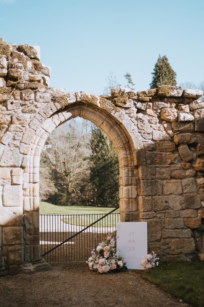 Wedding welcome sign at Brinkburn Priory styled with flowers