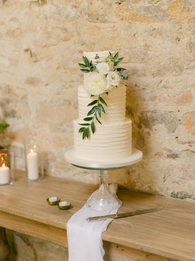 Buttercream wedding cake styled with fabric and candles